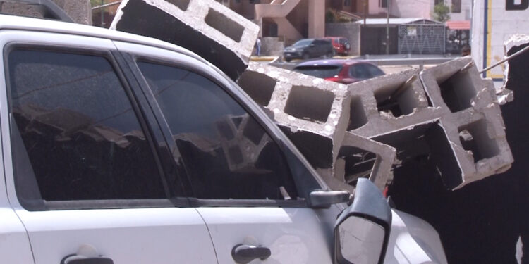 Vientos derriban barda y dañan dos vehículos en la capital