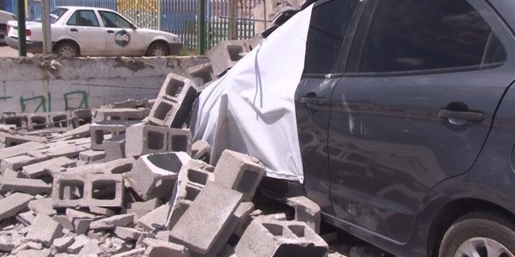 Vientos derriban barda y dañan dos vehículos en la capital