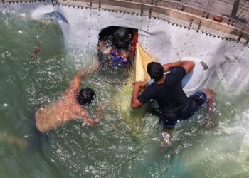 ¡Rapiña acuática! Personas se meten al río y se llevan mercancía de tráiler volcado