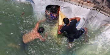 ¡Rapiña acuática! Personas se meten al río y se llevan mercancía de tráiler volcado