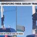Limpia parabrisas escala semáforo para reparar falla en la intersección